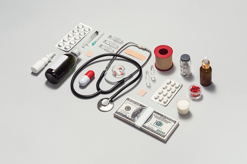 Medical flat lay on gray color background with money bundle, American dollar