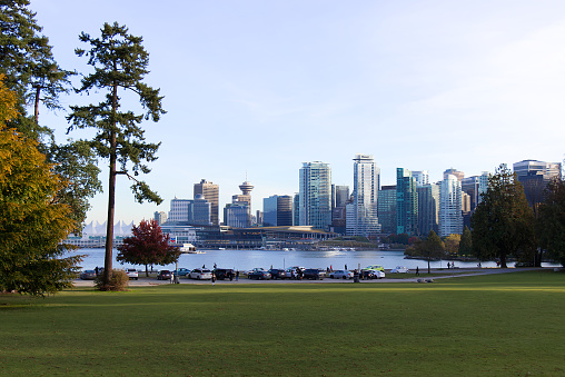 Vancouver, Canada - October 11, 2019: Scenic cityscape view of Vancouver skyline and Burrard Inlet from Stanley Park at sunny day