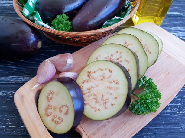 istock raw eggplant cut on a wooden background 1208230461