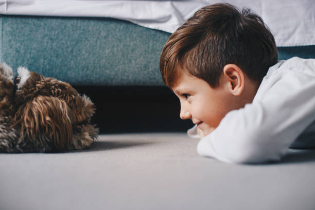 istock Cute boy plays on the floor on a carpet with dog 1208232848