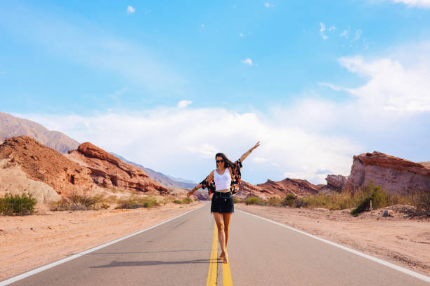 istock Woman walking down the empty rural road 1208234575