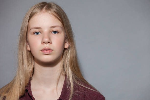 studioporträt eines teenagers auf grauem hintergrund - teenage girls blue eyes adolescence teenager stock-fotos und bilder