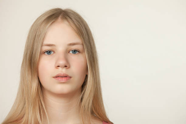 studioporträt eines teenagers auf beigefarbenem hintergrund - teenage girls blue eyes adolescence teenager stock-fotos und bilder