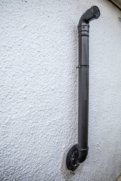 istock Black flue pipe from central heating boiler on an external masonary wall. 1208238368