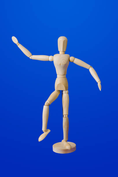 istock Dancing wooden toy figure on blue 1208239155