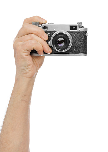 Vintage photo camera in hand isolated on white background