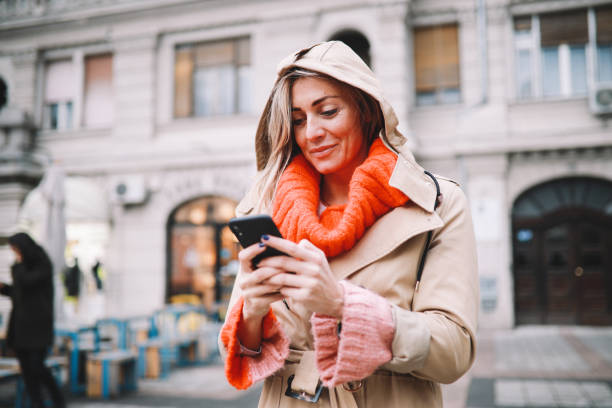 istock Fashionable woman checking apps on her smartphone 1208244579