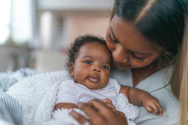 istock Happy mother snuggling baby 1208244862
