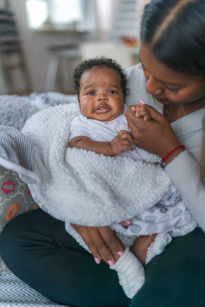 istock Woman holding baby at home 1208244864