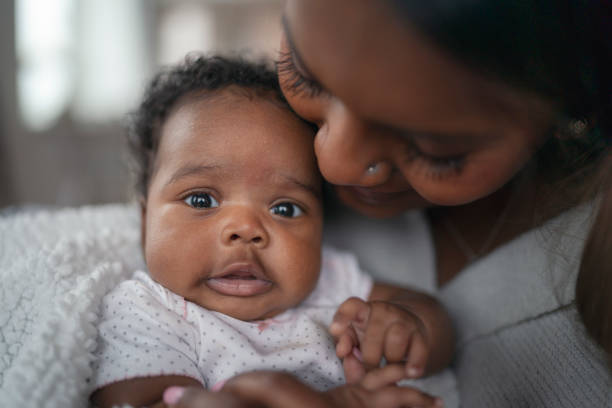istock Happy mother snuggling baby 1208244924