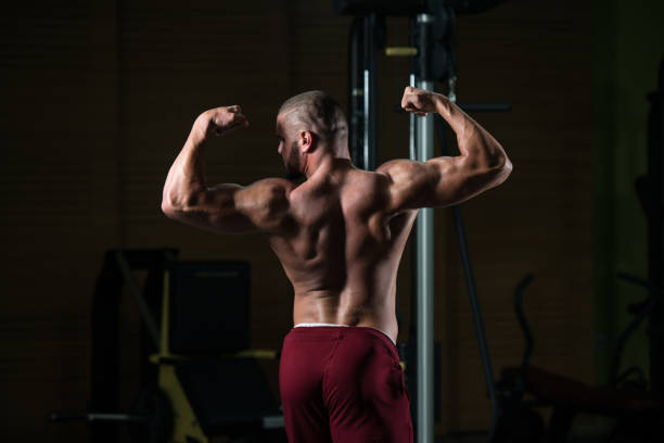 istock Handsome Muscular Man Flexing Muscles In Gym 1208245130
