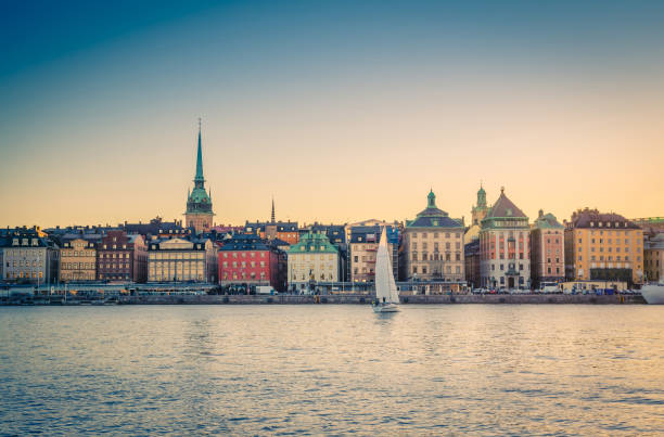 Panoramic view historical town quarter Gamla Stan, Stockholm, Sweden Panoramic view of old historical town quarter Gamla Stan with traditional typical buildings with colorful walls on Stadsholmen island and sail yacht on water Lake Malaren at sunset, Stockholm, Sweden strommen stock pictures, royalty-free photos & images