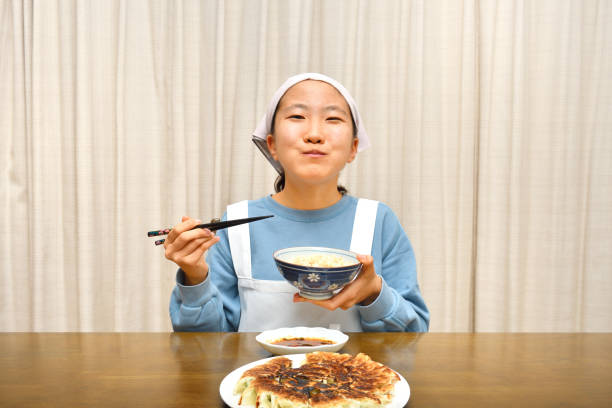 istock Japanese girl enjoys having Chinese dumplings 1208247326