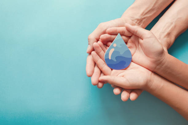 adult and child hands holding paper cut water drop, world water day,  clean water and sanitation, csr, save water,  ecology concept - save oceans imagens e fotografias de stock