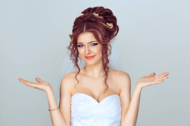 istock Bad things happens. Bride girl gesturing with both hands confusion i don't know making funny puzzled face against light blue background 1208255601