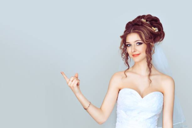 istock Look here, advertisement. Happy woman smiling showing look here at copy space at my text, product gesture with hand isolated light blue background 1208255629