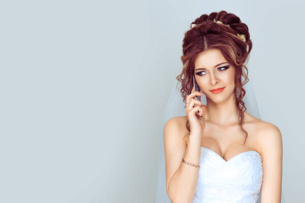 istock Sad and worried bride talking at mobile phone on light blue background 1208255800
