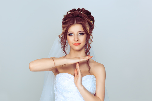 Closeup portrait young bride woman showing time out gesture with hands isolated on light blue background