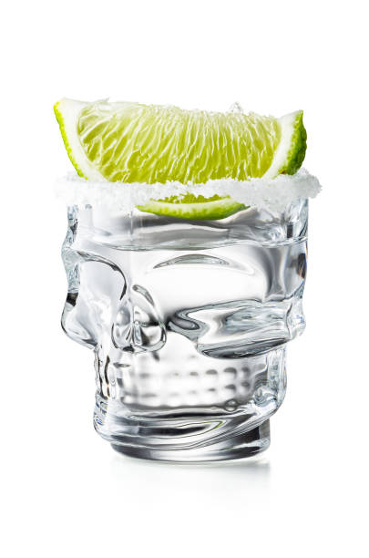 crâne shaped tequila glass shot with lime slice and salty rim, isolated on white background - crane shot photos et images de collection