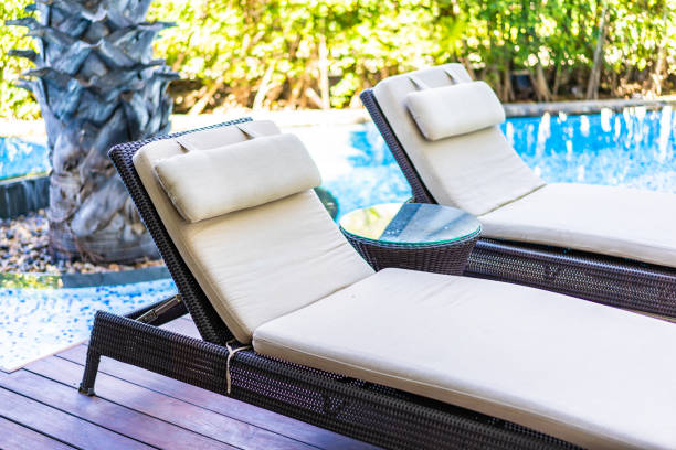 istock Empty chair deck lounge around swimming pool in hotel resort 1208259413