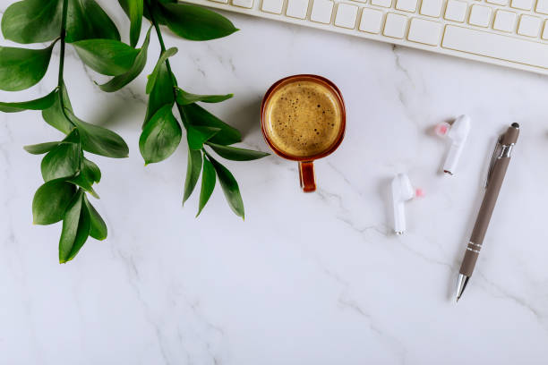 istock Workspace with office supplies and gadgets wireless headphones with keyboard notepad, pen cup of coffee 1208261554