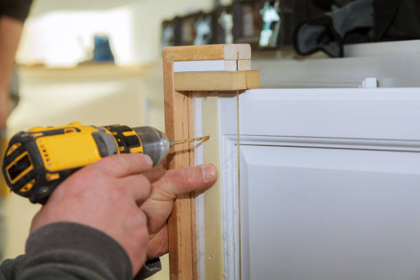 istock Master drills the cabinet door in the drilling a hole 1208261632