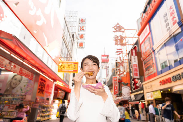 istock asian woman who eats Takoyaki ,Octopus balls, Osaka,Japan, 1208261908