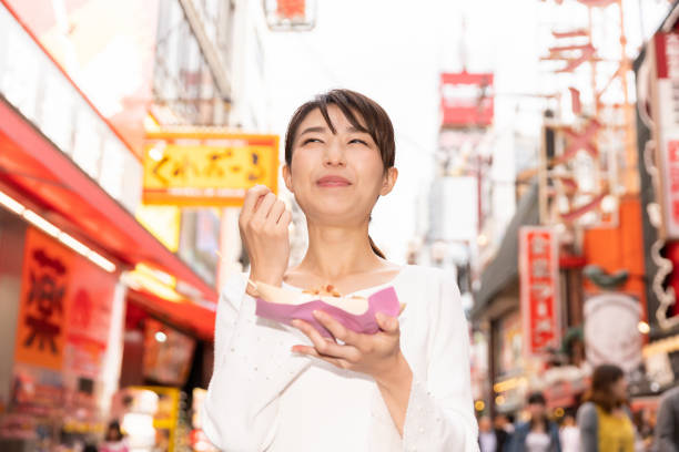 istock asian woman who eats Takoyaki ,Octopus balls, Osaka,Japan, 1208261925