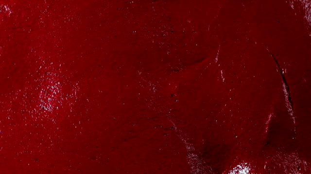 Blood Red wet slime putty surface texture as it slowly spins / loop able