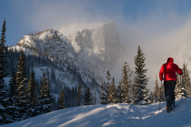 Hiker in Rocky Mountain National Park Hiking in snowshoes at Dream Lake, in Rocky Mountain National Park. snowshoeing snow shoe red stock pictures, royalty-free photos & images