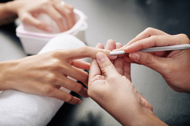 Nail master pushing cuticle Close-up image of nail master pushing cuticle with metal manicure tool cuticle photos stock pictures, royalty-free photos & images