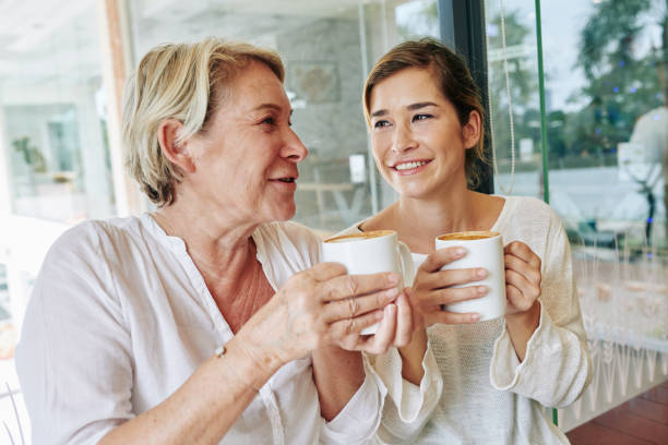 istock Mature woman drinking coffee with daughter 1208272201