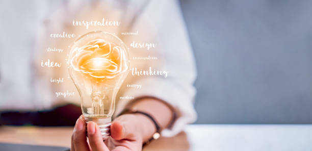 hand holding light bulb with innovation and creativity are keys to success. concept knowledge leads to ideas and inspiration. - light bulb business wisdom abstract imagens e fotografias de stock