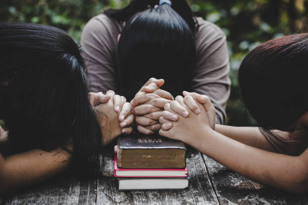 istock Group of different women praying together 1208278420