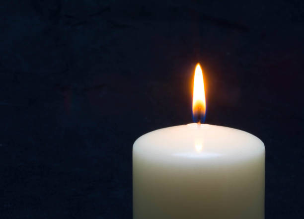 istock One candle flame burning in darkness 1208279466