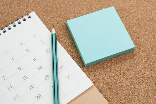 istock Meeting note, appointment and schedule, memo, ideas from brainstorm concept, blue paper sticky note with pencil and calendar on wooden background 1208291245