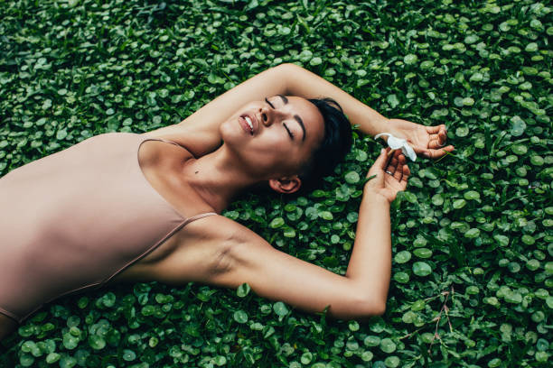 młoda piękna kobieta z tropikalnymi roślinami - spa treatment relaxation beauty in nature leaf zdjęcia i obrazy z banku zdjęć
