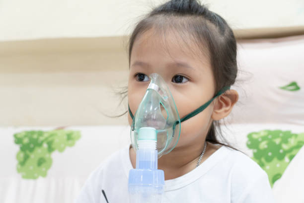 niña inhalando en casa - tubing child oxygen mask medical oxygen equipment fotografías e imágenes de stock