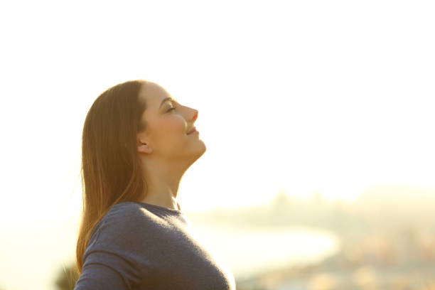istock Single woman breathing deeply fresh air at sunset 1208292854