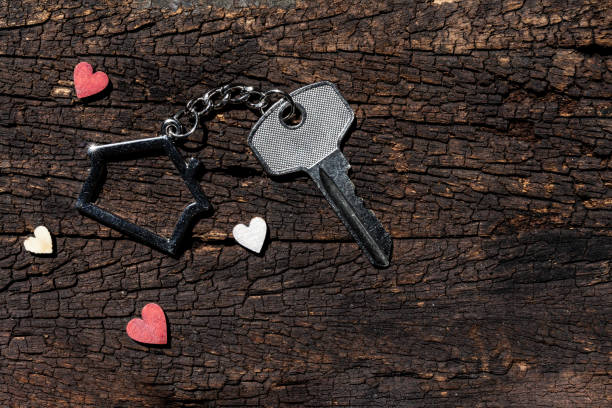 istock House key with home keyring decorated with mini heart on rusty wood background, copy space 1208292977