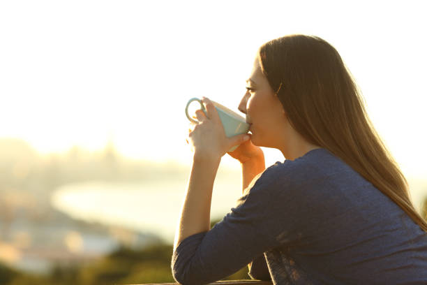 istock Satisfied woman drinking coffee at sunset watching views 1208293050