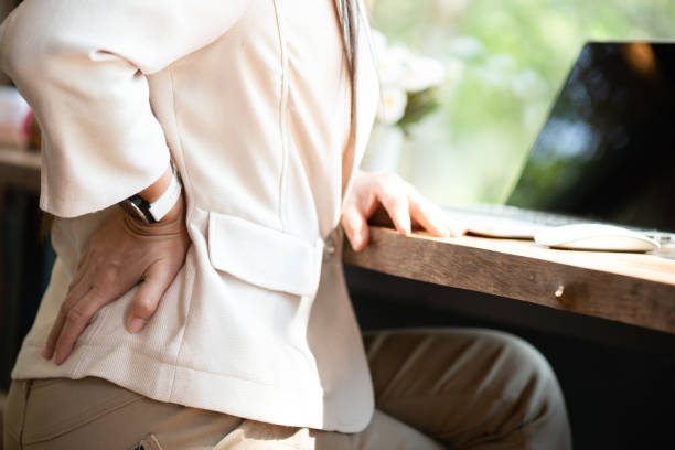 closeup woman with hands holding her back pain. office syndrome and healthcare concept. - physical injury backache occupation office imagens e fotografias de stock