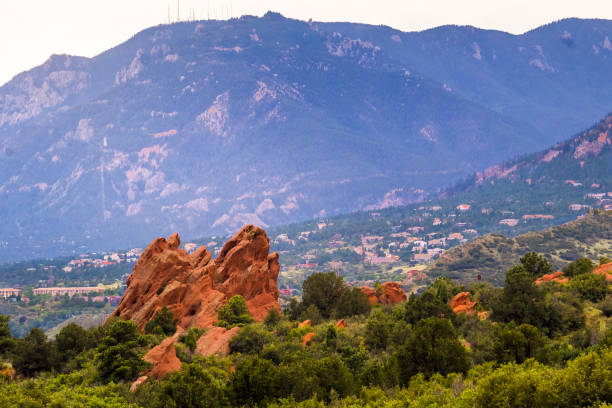 Garden of the Gods Park with the City of Colorado Spring behind it View of red rocks in Garden of the Gods, Colorado Springs, Colorado, and the city behind them; mountains in background colorado springs city stock pictures, royalty-free photos & images