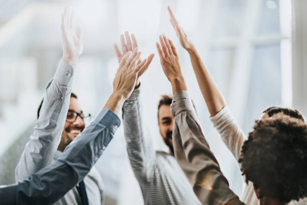 istock Successful business team raising their arms in the office. 1208305607