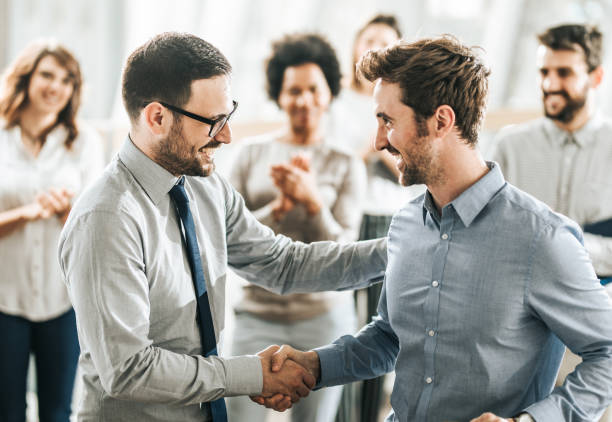 istock Young happy businessmen shaking hands after reaching an agreement. 1208306234