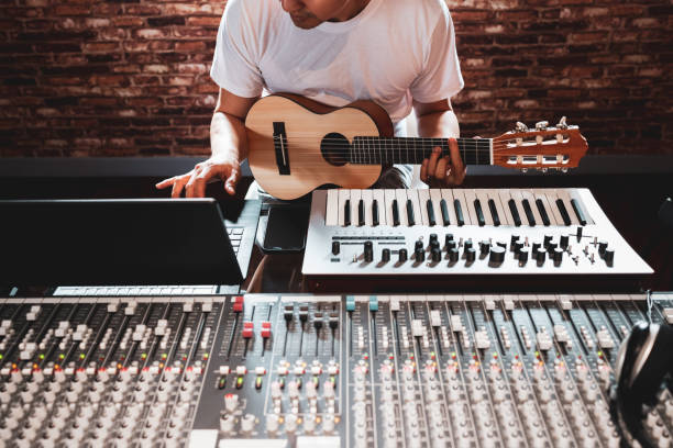 cantautore asiatico che suona la chitarra acustica per fare musica al computer in studio di registrazione domestica - human finger sound mixer music producer foto e immagini stock