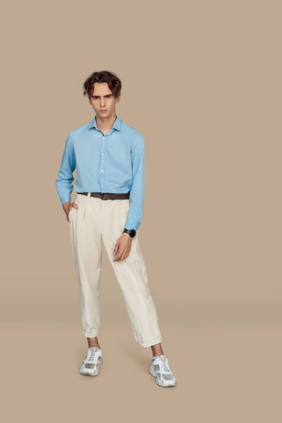 istock Freestyle. Man in formal wear standing isolated on gray posing serious 1208307813