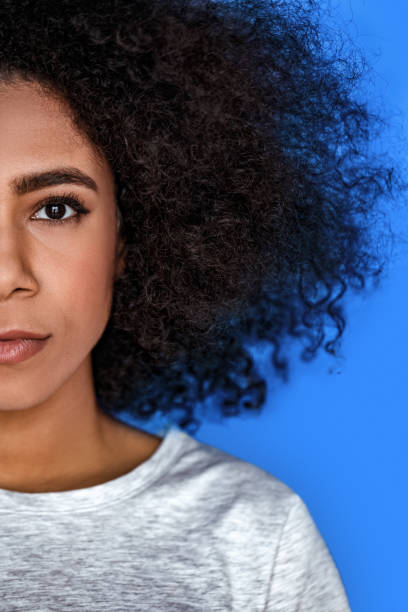 istock Freestyle. girl standing isolated on blue half face serious close-up 1208308004