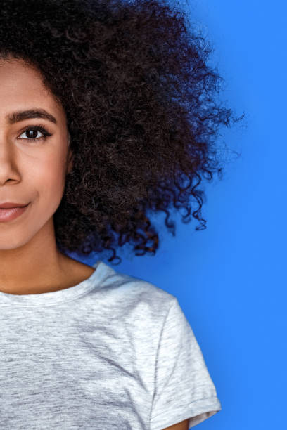 istock Freestyle. girl standing isolated on blue half face smiling happy 1208308007