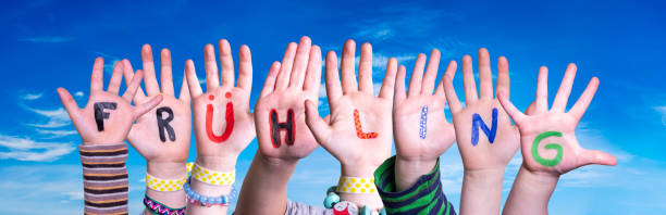 istock Children Hands Building Fruehling Means Spring, Blue Sky 1208308228